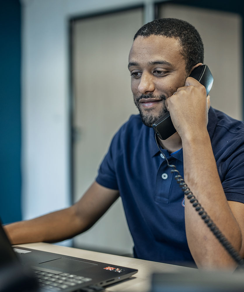 Technicien Synergies Tech au téléphone lors de téléassistance
