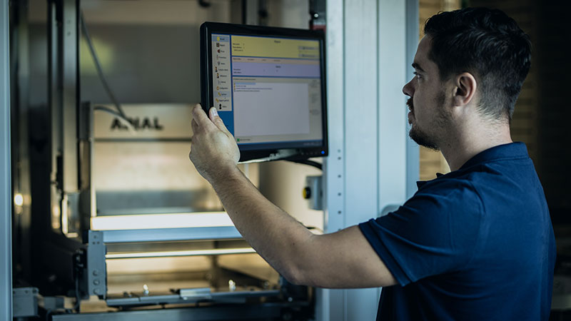 technicien maintenance automate Technicien regardant un écran lors de la maintenance d'un automate